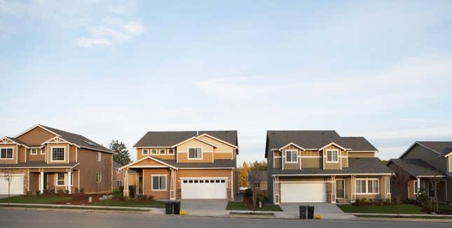 Row of houses with garbage and recycling bins on roadside