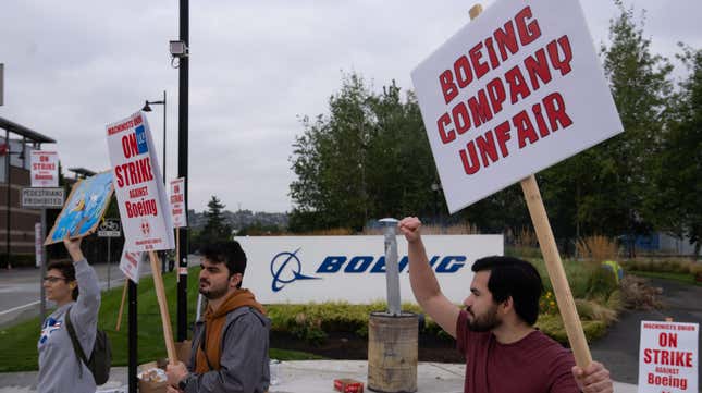 Boeing employees hold up signs on a picket line