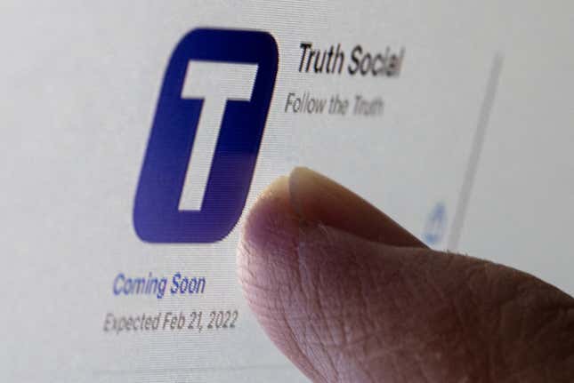 A finger presses the Truth Social app on a phone