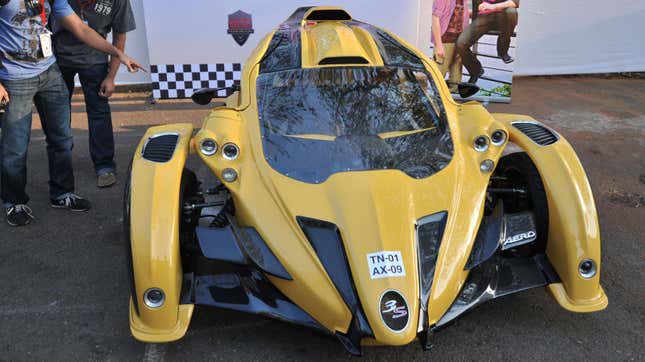 A photo of a yellow Campagna T-Rex three-wheeled car. 