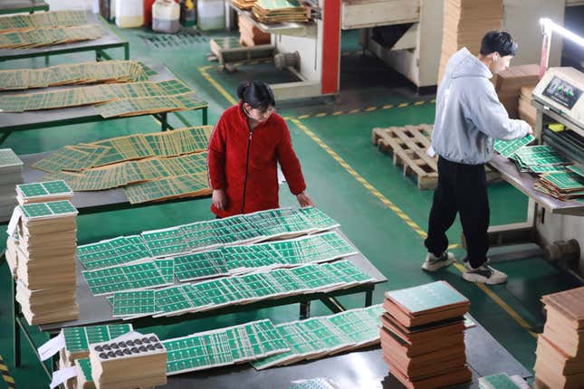 A woman sorts out printed circuit board at a factory in Hangzhou in eastern China&#39;s Zhejiang province Sunday, Jan. 7, 2024. A survey of factory managers in China released Wednesday, Jan. 31, shows manufacturing contracted in January for a fourth straight month, reflecting weak demand and a faltering recovery in the world&#39;s second-largest economy. (Chinatopix Via AP)