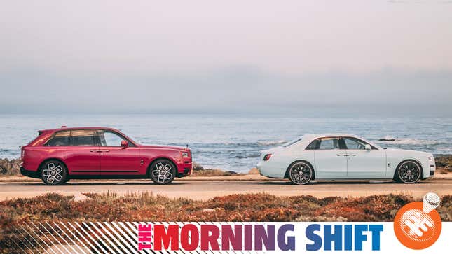 A photo of two Rolls Royce cars parked next to the sea. 