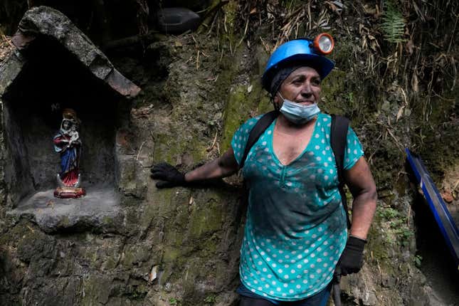 Maria Julia Pena, 66, stands outside an informal mine near the town of Coscuez, Colombia, Wednesday, Feb. 28, 2024. To enter the small mines around Coscuez, women wear rubber boots and helmets and carry drills just like the men. (AP Photo/Fernando Vergara)