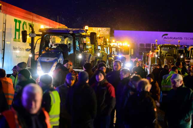 Farmers stand together with truck drivers at a meeting point shortly before they set off on a protest action in Uelzen, Germany, Monday, Jan. 8, 2024. Farmers blocked highway access roads in parts of Germany Monday and gathered for demonstrations, launching a week of protests against a government plan to scrap tax breaks on diesel used in agriculture.(Philipp Schulze/dpa/dpa via AP)