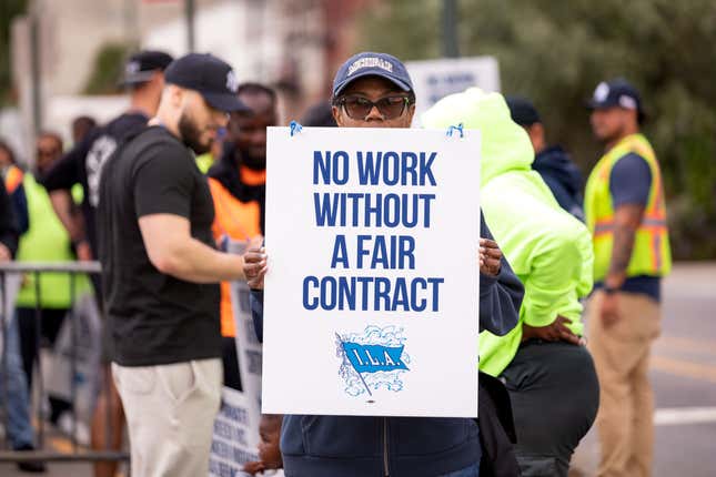 Des travailleurs manifestent devant le terminal à conteneurs de Red Hook à Brooklyn. Des membres de l’International Longshoreman’s Association ont débrayé dans tous les grands ports de la côte est et de la côte du Golfe des États-Unis après avoir échoué à parvenir à un accord sur de meilleurs salaires et l’automatisation avec l’United States Maritime Alliance. Cette grève est la première du syndicat depuis 1977 et pourrait se propager à travers la plus grande économie du monde, provoquant des troubles politiques quelques semaines seulement avant l’élection présidentielle.