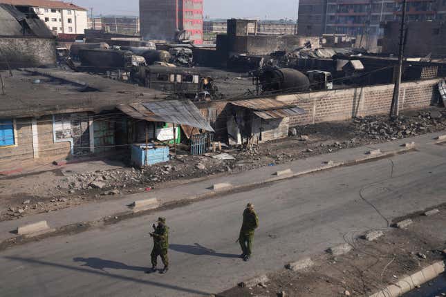 Police walk near a gas depot after a fire caused by an explosion at an industrial building in Nairobi, Kenya, Friday, Feb. 2, 2024. (AP Photo/Brian Inganga)