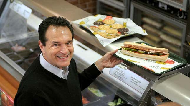 fred deluca posing with Subway sandwich