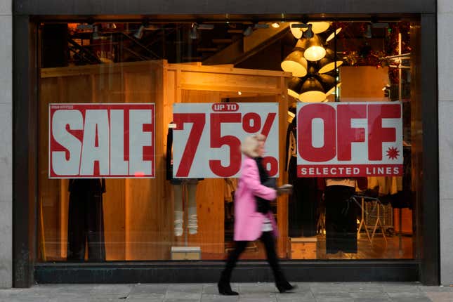 A shopper passes a window displaying a sale sign on Oxford Street in London, Wednesday, Dec. 20, 2023. Inflation in the U.K. as measured by the consumer prices index has eased back to its lowest level in more than two years. The Office for National Statistics said Wednesday that inflation dropped to 3.9% in the year to November, its lowest level since Sept. 2021, from 4.6% the previous month. (AP Photo/Kirsty Wigglesworth)