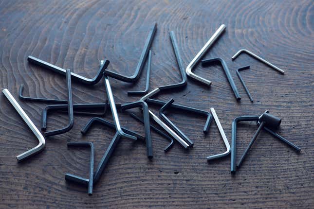 A pile of Allen wrenches on a wood surface.