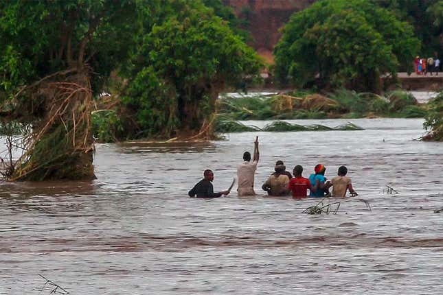 People walk on a road swept by flooding waters in Chikwawa, Malawi, Tuesday Jan. 25.