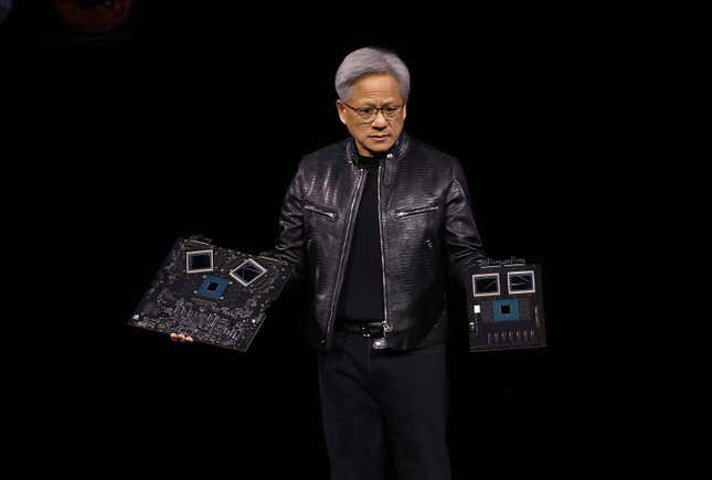 Jensen Huang trägt eine schwarze Lederjacke und hält zwei Motherboards in der Hand