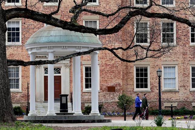 In this March 18, 2020, file photo, people remove belongings on campus at the University of North Carolina in Chapel Hill, N.C.