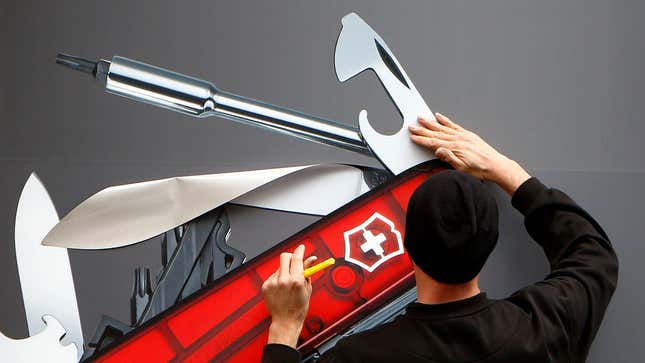A worker sticks a picture of a Swiss army knife on a window of a Victorinox store in Zurich, Switzerland