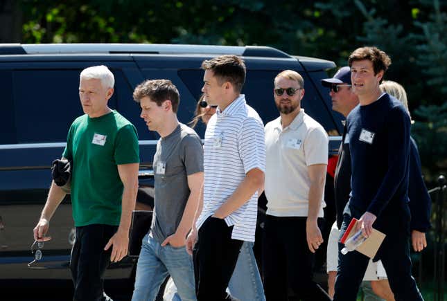 Five men walking in a group, some are looking forward and some are looking to the side at the camera