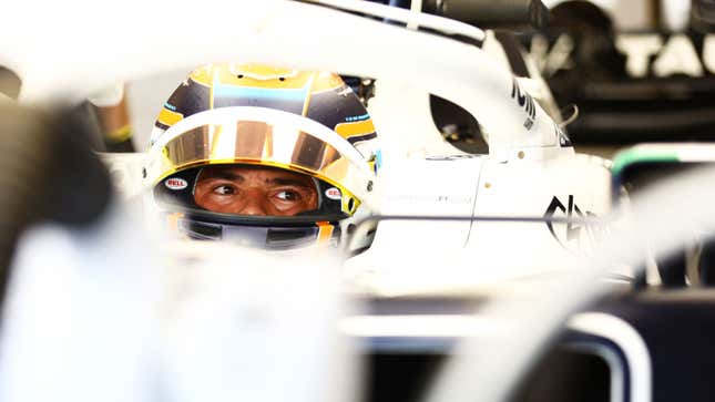 A photo of Nyck de Vries sat in an Alpha Tauri F1 car in the paddock.