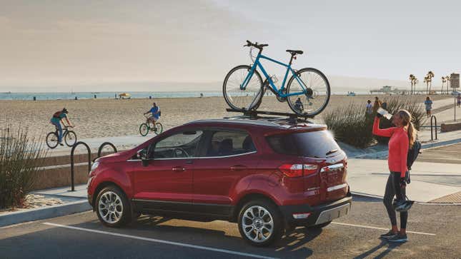 A red ford ecosport parked at the beach bike path in Long beach with a bike on its roof