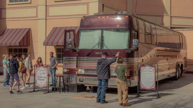 A photo of tourists looking at Dolly Parton's tour bus. 