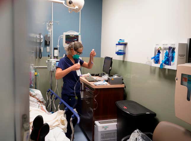 FILE - Registered nurse Sandra Younan sets up a new intravenous line for a patient under her care at Providence Cedars-Sinai Tarzana Medical Center in the Tarzana neighborhood of Los Angeles on March 11, 2021. A new rule in California aims to limit health care price increases to just 3% each year. The Health Care Affordability Board approved the rule on Wednesday, April 24, 2024. It sets a statewide cost growth target of 3% each year. (AP Photo/Damian Dovarganes, File)