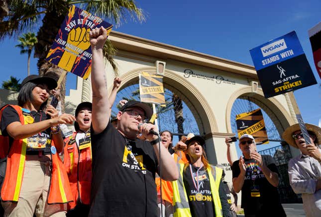 FILE - SAG-AFTRA chief negotiator Duncan Crabtree-Ireland, left, raises a fist as he rallies striking actors outside Paramount Pictures studio, Friday, Nov. 3, 2023, in Los Angeles. According to an annual report published Thursday, Feb. 15, 2024, from the Labor Action Tracker, a collaboration between researchers at Cornell University and the University of Illinois, those involved in work stoppages climbed 141% in 2023 — from 224,000 to 539,000 striking workers. (AP Photo/Chris Pizzello)