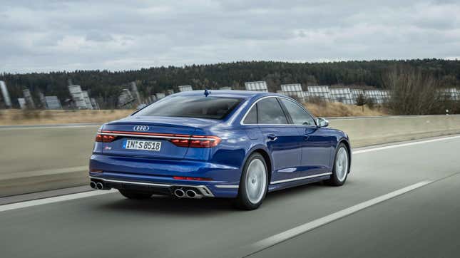 trois quarts arrière d’une Audi S8 bleue roulant sur une route