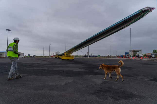 An employee works to transport a wind turbine blade for painting at the Adani New Industries Limited, one of India&#39;s largest solar panels and wafers manufacturing facility in the port town of Mundra in Western India&#39;s Gujarat state, India, Wednesday, Sept. 20, 2023. It&#39;s one of the few locations in India where most solar energy components are made from scratch. (AP Photo/Rafiq Maqbool)