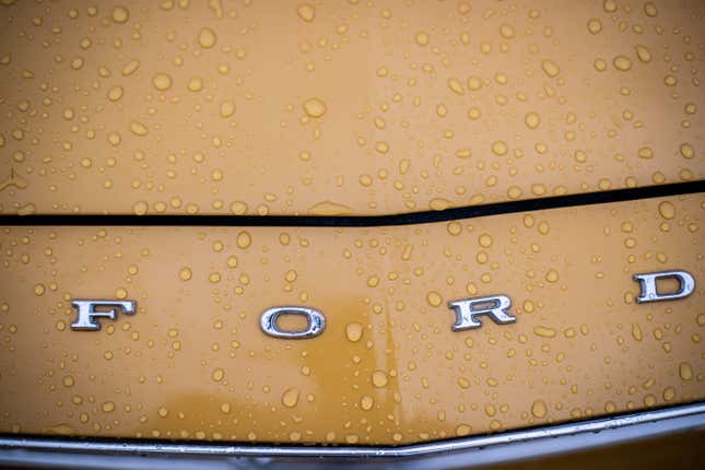 A detail shot of beads of water on a yellow Ford hood 