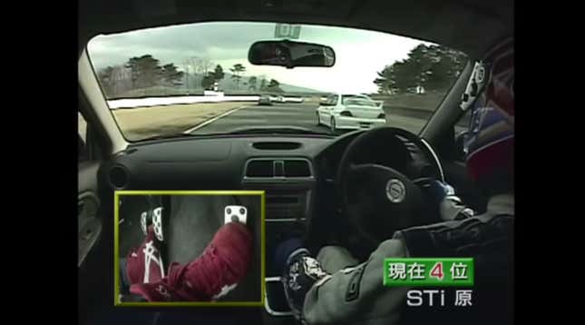 A race driver in a Subaru chases a Mitsubishi on track.