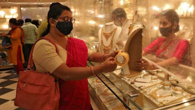 Woman looks at a gold necklace at a jewellery showroom during Dhanteras, a Hindu festival associated with Lakshmi, the goddess of wealth, amidst the spread of COVID-19 in Kolkata, India, November 13, 2020.