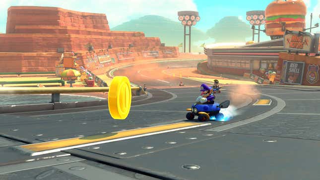 Waluigi drifts towards a coin ahead of other drivers.
