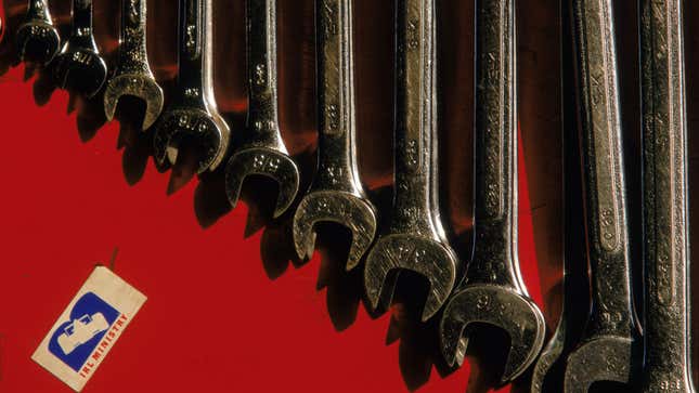 A set of ten differently sized box wrenches in a red tool box. 