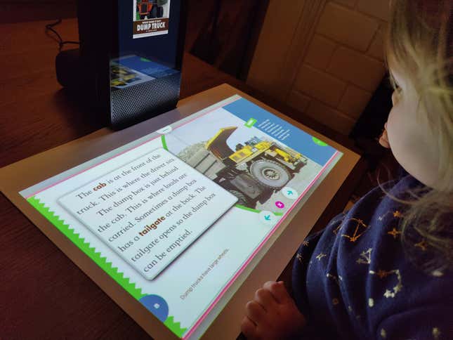 A photo of a kid looking at the Amazon Glow's projection of a story book