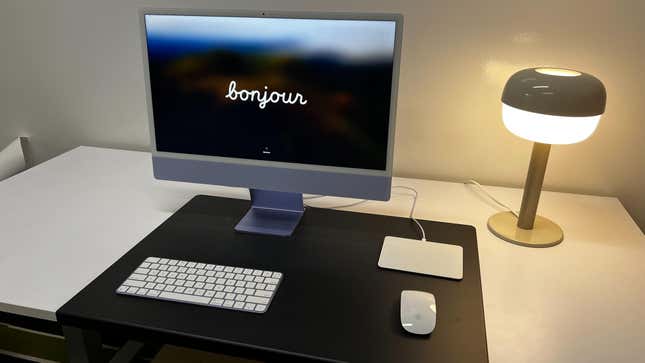 Apple iMac set up on desk with mouse, keyboard and trackpad. 