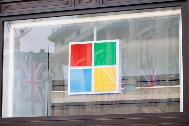 Microsoft logo behind a window reflecting two UK flags