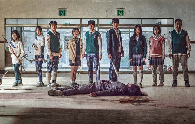The high school cast of the Korean drama All of Us Are Dead, standing over a dead zombie. 