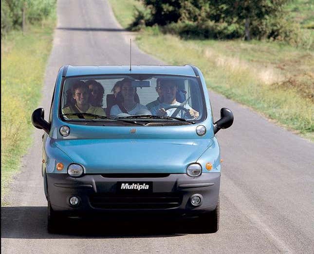 Un Fiat Multipla turquesa lleno de gente conduciendo directamente a la cámara