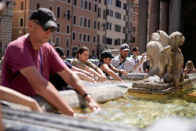 FILE - People cool off at a fountain in front of the Pantheon, in Rome, Saturday, Aug. 19, 2023, where temperatures were expected to reach as high as 37 Celsius (98 Farenheit). This was the hottest summer on record across the globe, forcing many tourists to rethink how and where they travel. (AP Photo/Andrew Medichini, FIle)