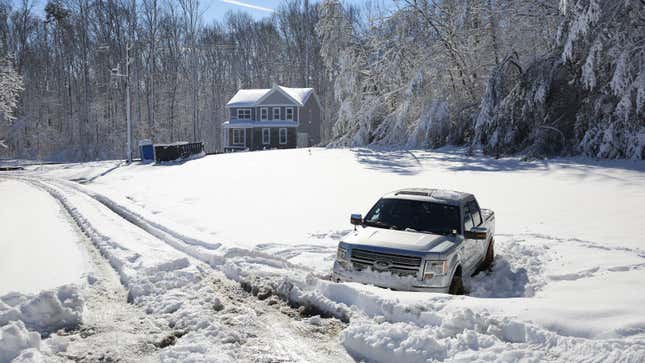 A photo of a truck abandoned in the snow. 