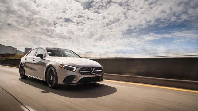 A photo of a silver Mercedes A Class sedan driving along a highway. 