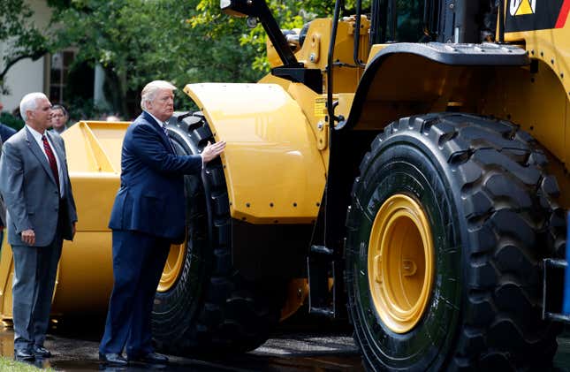 Trump, looks at a Caterpillar front end loader, made in Illinois.