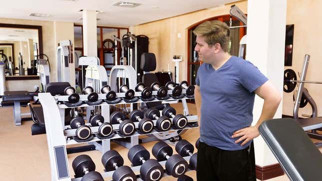 Image for article titled New Gym Member Lingers By Free Weights For Several Seconds Before Returning To Elliptical Machine