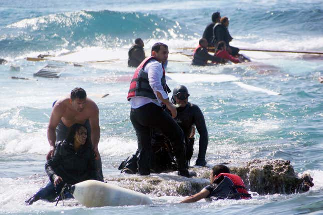 A man rescues an migrant from the Aegean sea, after a boat carrying migrants from Africa ran aground the Greek island of Rhodes on Apr. 20, 2015.