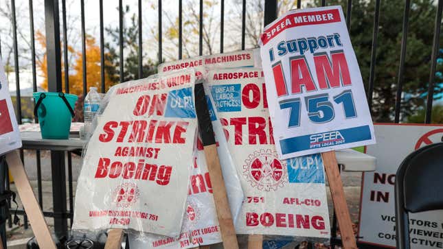 Carteles de huelga de Boeing apoyados contra una valla