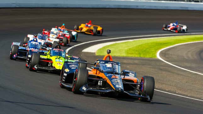 A photo of eight IndyCar racers at a circuit. 