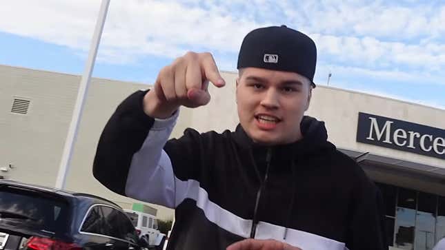 Tanner Cook stands in front of a car dealership in a November 2022 Classified Goons video.