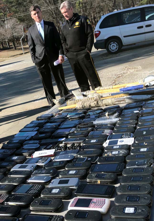 FILE - South Carolina Corrections Director Bryan Stirling and Richland County Sheriff Leon Lott talk after a news conference outside Broad River Correctional Institution in Columbia, S.C., Wednesday, Jan. 31, 2018. Federal prosecutors in April charged a former prison supervisor with brining in 173 contraband cellphones and taking $219,000 in bribes over three years. (AP Photo/Meg Kinnard, File)