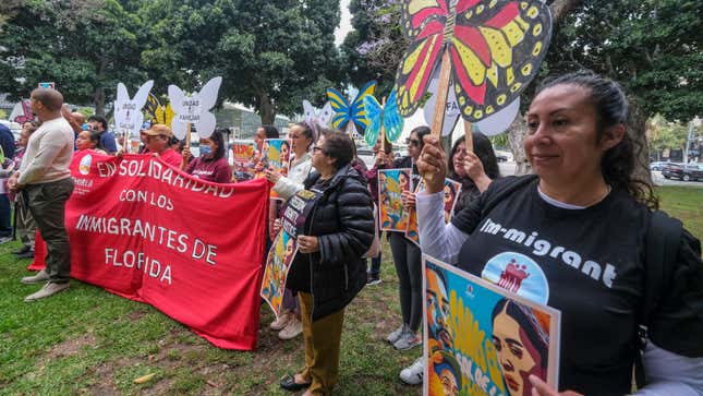 People holding signs protest during a ‘’Solidarity Rally with Floridians” to condemn Florida Governor Ron DeSantis’ attacks on immigrants through legislation such as SB 1718, outside City Hall in Los Angeles, June 28, 2023.