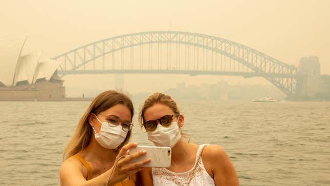 Tourists take a selfie while wearing face masks due to heavy smoke on Dec. 19, 2019 in Sydney, Australia.