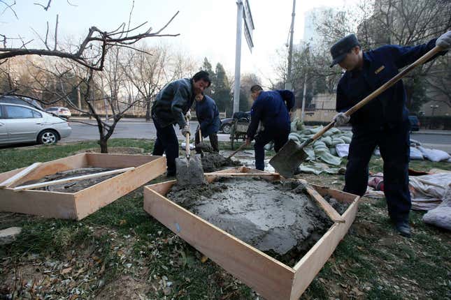 An underground shaft, in which a person was found living in, is filled up by law enforcement workers in Beijing, December 6, 2013. According to local media, around five underground shafts, in which people were living in, were blocked by city officials on Friday morning at a neighbourhood in Beijing. One of the dwellers, Quan Youzhi, 66, has been living in the shafts, which were originally used for the city's heating system, for around 20 years as she could not afford to pay rent for housing after she came to Beijing, and has since relocated several times after being chased away by law enforcement officials. Quan supports herself with about 10 yuan ($1.64) daily, which she makes from collecting waste bottles. Picture taken December 6, 2013.