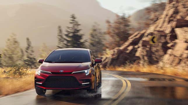 A red corolla hybrid driving on a wet mountain road