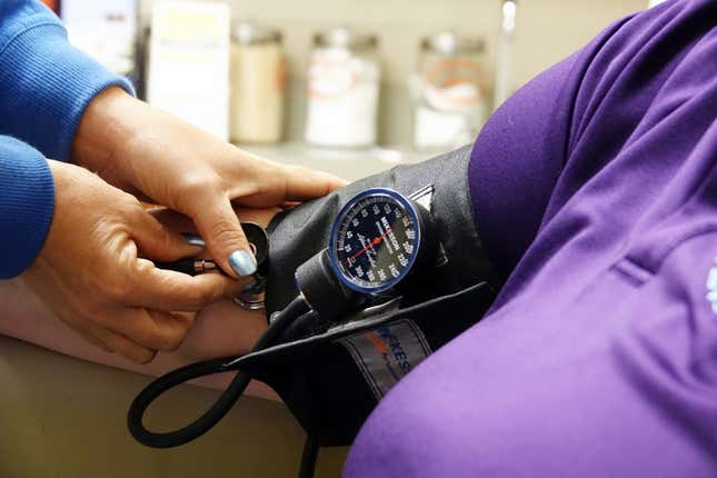 A nurse takes the blood pressure of a patient